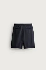 Bermuda regular fit de tejido elástico color blanco, con cintura elástica ajustable mediante cordón, bolsillos delanteros y bolsillos traseros de vivo.