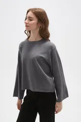 Remera de manga larga confeccionada en viscosa, con cuello redondo a la base y diseño holgado.