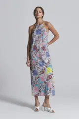 Vestido largo de algodón y seda con estampado multicolor. Tiene breteles finos que se atan en la espalda, escote recto y corte levemente entallado.
