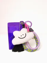 Llavero con tarjeta identificadora transparente con borde violeta, dije de nube blanca con cara sonriente, borla de hilos negros, mosquetón y argolla violeta, cinta de soga trenzada con diseño geométrico en amarillo, violeta y blanco.