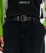 Cinturón de poliuretano color negro con doble hilera de ojales metálicos y hebilla cuadrada de metal.