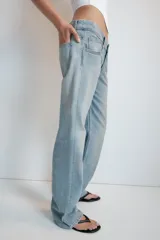 Jeans de mezclilla de tiro medio con cinco bolsillos, diseño relaxed fit de corte recto y amplio, con efecto lavado y desgaste frontal.