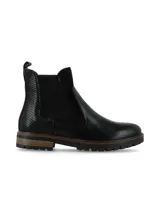Botin tipo Chelsea de caña corta color negro, confeccionado en cuero con textura efecto reptil y detalles de nobuk, con elásticos laterales y suela track con detalle en tono madera.