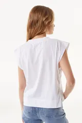 Top blanco con cuello redondo y sisas amplias. Estampado frontal con forma de labios en colores amarillo, azul y negro.