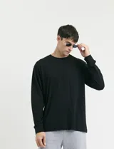 Remera de manga larga color negro, con cuello redondo y puños en punto canalé.