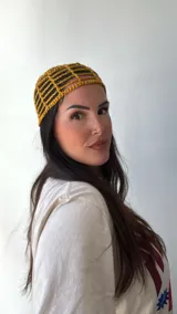 Gorro tipo bucket de crochet color mostaza con diseño de red.