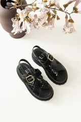 Sandalias de cuero color tostado y blanco, con plataforma track y hebilla metálica.