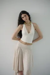 Top blanco con lunares negros, escote en V y tiras para atar detrás del cuello.