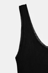Camiseta de tirantes anchos confeccionada en algodón con textura acanalada. Presenta escote redondo con detalle de aplicación de tejido tipo tul a tono y bajo recto.