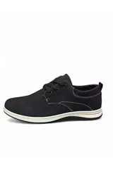 Zapato estilo casual de color negro, confeccionado con acabado símil nobuk, cordones negros y suela blanca con costuras visibles.