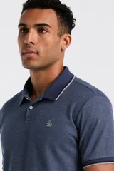 Polo de hombre color azul marino jaspeado, con cuello y ribetes en contraste azul oscuro. Presenta un pequeño logo bordado en el pecho.