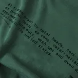 Remera de algodón color verde oscuro con cuello redondo y manga corta. Presenta la palabra "FORMER" estampada en negro en el centro del pecho.