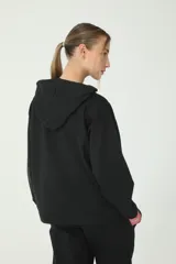 Buzo hoodie negro oversize de rústico, con capucha y cordones de ajuste color salmón y verde. Etiqueta con logo Basset 00'S en la manga derecha.