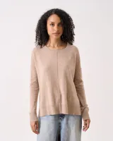 Sweater de cashmere color beige, con cuello redondo, sisa caída y silueta relajada. Presenta detalles acanalados en el ruedo y los puños, y un sutil diseño vertical en el centro delantero.