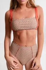 Bombacha de bikini de tiro alto, estilo semivedetina, con estampado geométrico en tonos marrones y beige, y tiras laterales color naranja.