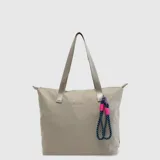 Bolso tipo tote bag marca Bubba, modelo Ontario Mini, en color beige con asas de hombro integradas y cierre superior. Cuenta con un llavero decorativo de cordón azul y fucsia con detalles en metal y el logo de la marca estampado en el frente.