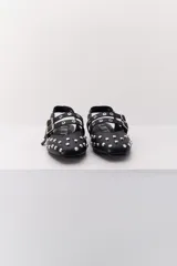 Balerina negra de cuero con punta fina y dos correas marrones con hebilla sobre el empeine. Decorada con tachas plateadas.