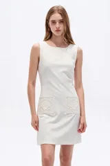 Vestido corto blanco de viscosa, sin mangas, con cuello redondo a la base y bolsillos frontales con apliques bordados.