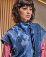 Chaleco de lana merino afieltrada, con grandes hombros y entallado a la cintura. El cuello es un lazo que se puede anudar de infinitas maneras. El color "azules" es único, renace del teñido artesanal con la técnica Tie Dye permitiendo descubrir diferentes matices y acuarelas únicas.
