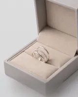 Anillo triple de acero quirúrgico color plateado, compuesto por tres aros finos unidos, uno de ellos con textura granulada y detalles de circón.