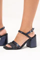 Sandalias de cuero azul con brillo, de horma cuadrada, doble tira delantera y ajuste con hebilla en la parte superior. Plataforma delantera de 1 cm y taco cuadrado de 8 cm.