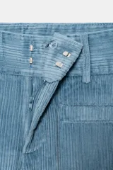 Pantalón de tiro alto con corte flare, confeccionado en pana. Presenta cintura ancha con trabillas, falsos bolsillos delanteros y cierre frontal con cremallera, botón oculto y ganchos metálicos.