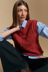 Chaleco tejido color crema con diseño de rombos calados, cuello redondo y sisas.