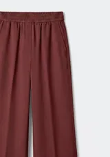 Pantalón de tiro medio con cintura elástica y corte recto de pierna ancha. Presenta pinzas frontales y bolsillos laterales.