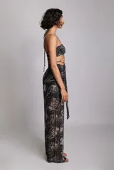 Pantalón palazzo de tiro alto con cintura elástica y cordones ajustables. Estampado floral en tonos blanco y negro.