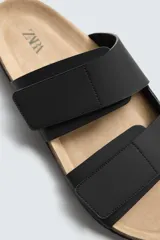 Sandalias marrones con doble tira ancha en el empeine, acabado engomado y ajuste con cierres adherentes. Plantilla anatómica y suela de corcho.