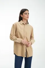 Camisa marrón de pana con cuello clásico, cierre con botones y dos bolsillos frontales con solapa.
