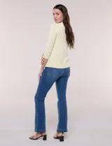 Cardigan de punto fino color amarillo con escote a la base, mangas tres cuartos y abotonadura frontal con botones metálicos decorativos.