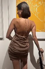 Vestido corto con diseño a rayas rojas y blancas, escote halter pronunciado, drapeado en la cadera y un lazo integrado que cuelga al costado.