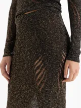 Pollera midi de tejido de punto con hilos metalizados, de tiro alto y silueta ajustada con leve vuelo en el ruedo.