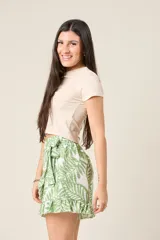 Short pollera con estampado de hojas color marrón y blanco, diseño cruzado, volados y lazo en la cintura.