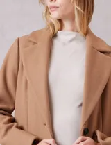 Tapado largo de lana Michael Kors, de corte recto y silueta estructurada. Presenta cuello con solapas amplias, cierre frontal con botones y bolsillos laterales con tapa. Incluye forro interno a tono.