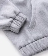 Buzo abierto con cierre frontal, confeccionado en tejido fleece color gris. Presenta capucha con borde de piel sintética, mangas largas con puños elásticos y bordado con lettering 'Clash' en el pecho.