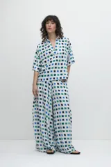 Pantalón de corte ancho con estampa geométrica de cuadrados azules, verdes y blancos.