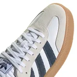 Championes Adidas Samba XLG con diseño clásico de perfil bajo. Presentan una base de cuero blanco con detalles en denim oscuro en las icónicas tres tiras y el talón. Incluyen refuerzos de gamuza en la puntera y la zona de los cordones, junto con una suela de goma color caramelo con relieve.