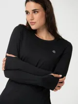 Polera de manga larga técnica, color negro, con cuello redondo y diseño ajustado. Presenta aberturas para los pulgares en los puños y un pequeño logo reflectante en el pecho.