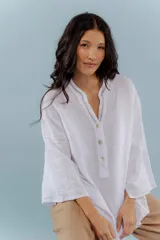 Camisa blanca de lino con escote en V y bordado multicolor.