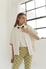 Pantalón de corte acampanado con diseño estampado en tonos verdes y amarillos.