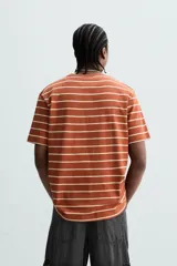 Remera color arena de corte recto, cuello redondo y mangas cortas.