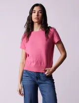 Buzo tejido de hilado fino color rosado, con cuello redondo y mangas cortas.