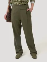 Pantalón de lino orgánico y viscosa color verde militar, de corte recto y tiro alto. Presenta pinzas en la parte delantera y detalle de botón en el lateral.