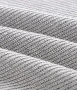 Remera polo marrón de tejido de tricot texturizado, de manga corta, con cuello polo abotonado y detalles de rayas blancas en el cuello.