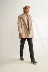 Saco de lana color tostado, con solapa, doble abotonadura, bolsillos, canesú y charreteras. Prenda de uso diario.