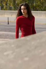 Vestido mini de manga larga en punto elástico color bordó, con escote cruzado en V, corte ajustado y frunces laterales que crean un efecto drapeado.