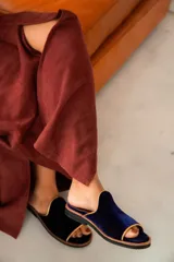 Sandalias de terciopelo azul marino con ribete dorado y plantilla de cuero tostado, de diseño abierto en la punta.