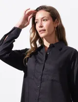 Camisa color verde oliva de lyocell, marca Cyrus. Tiene cuello con solapa, abertura central con botones, mangas 3/4 regulables con presilla y botón, y dos bolsillos delanteros aplicados.